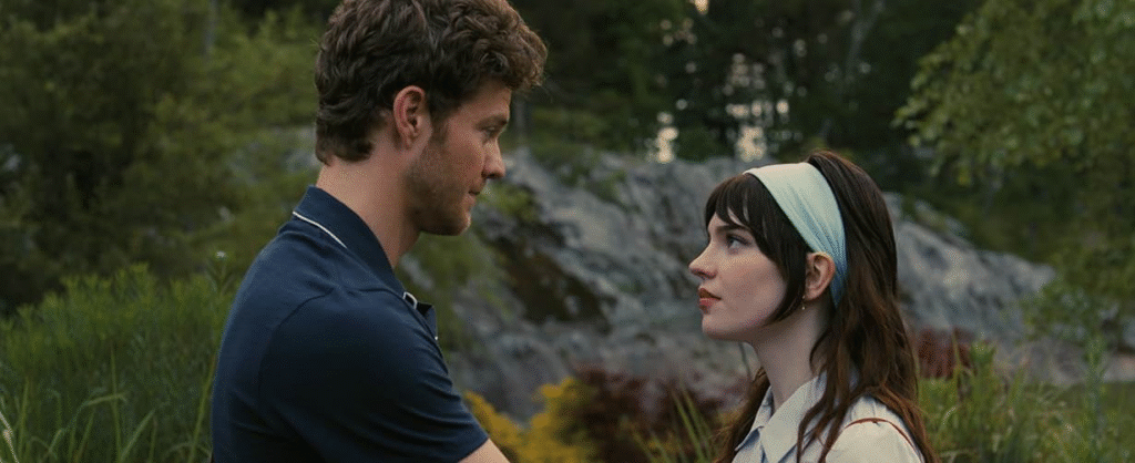 Companion (2025): The lead couple looking into each other's eyes.