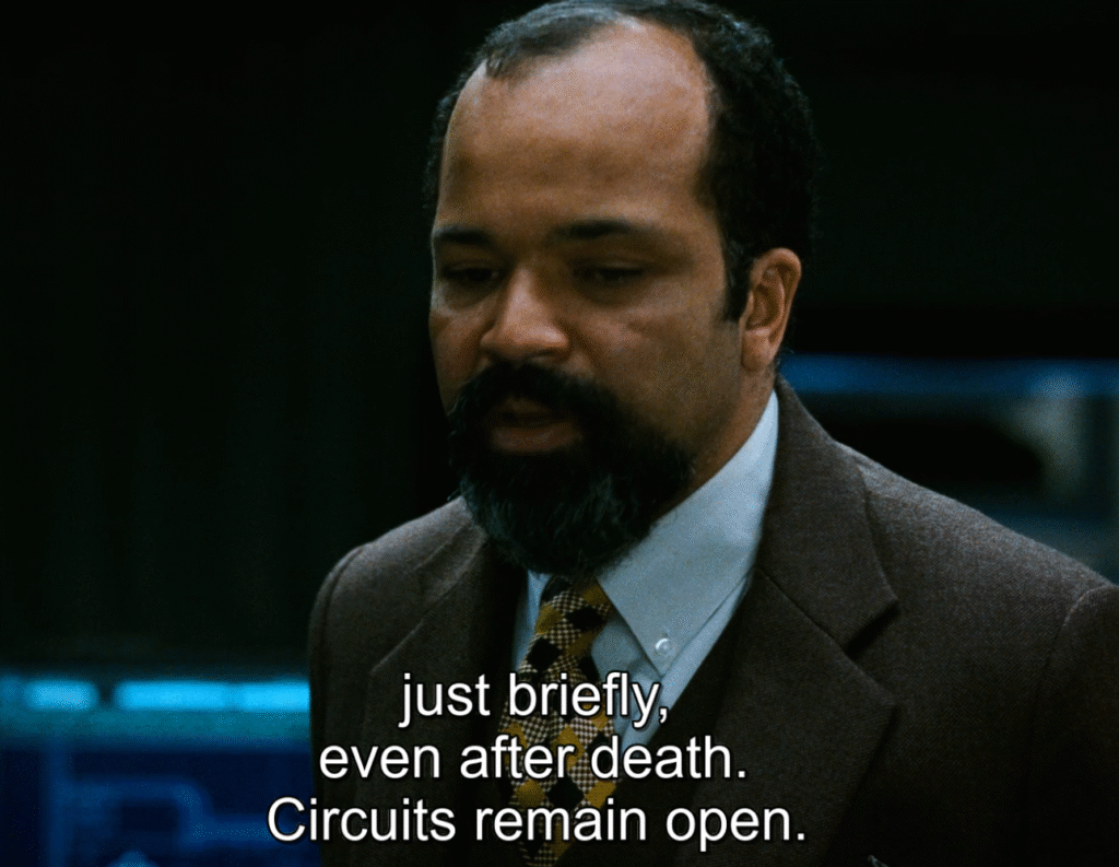 Shot from Source Code (2011): Dr. Rutledge explaining what is source code. 