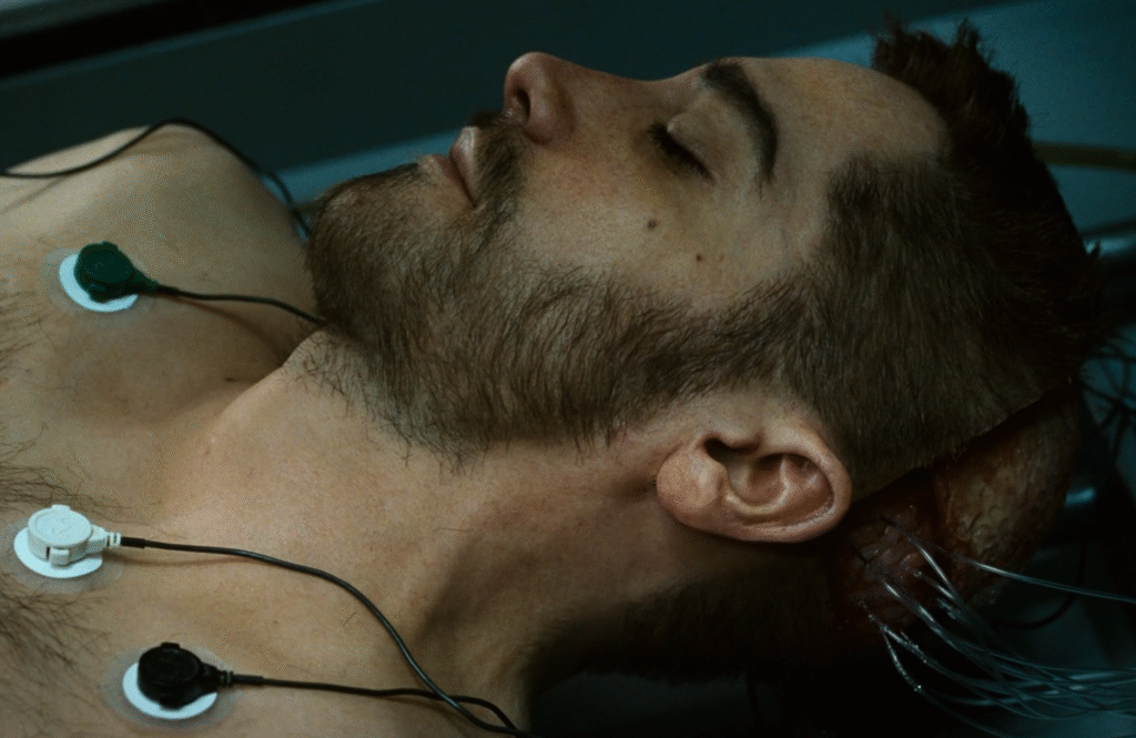 Shot from Source Code (2011): Colter's body hooked to the source code. 